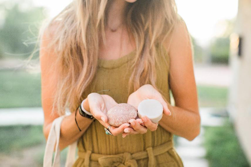 a woman holding shampoo bars