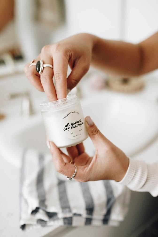 a close-up of someone getting ready to use all natural dry shampoo