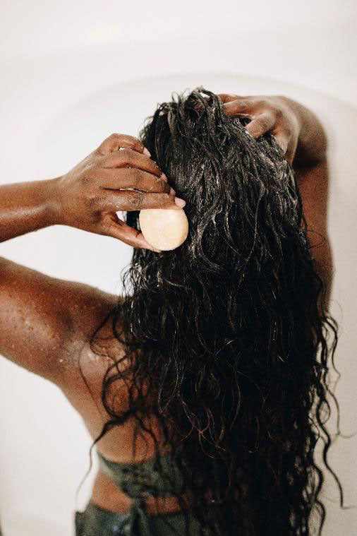 a woman washing her hair with a shampoo bar